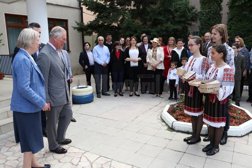 Carmen Netedu, director de programe al Fundației FARA și manager al Căminului „Sf. Nicolae” Suceava și copii care îi oferă un cadou Prințului Charles