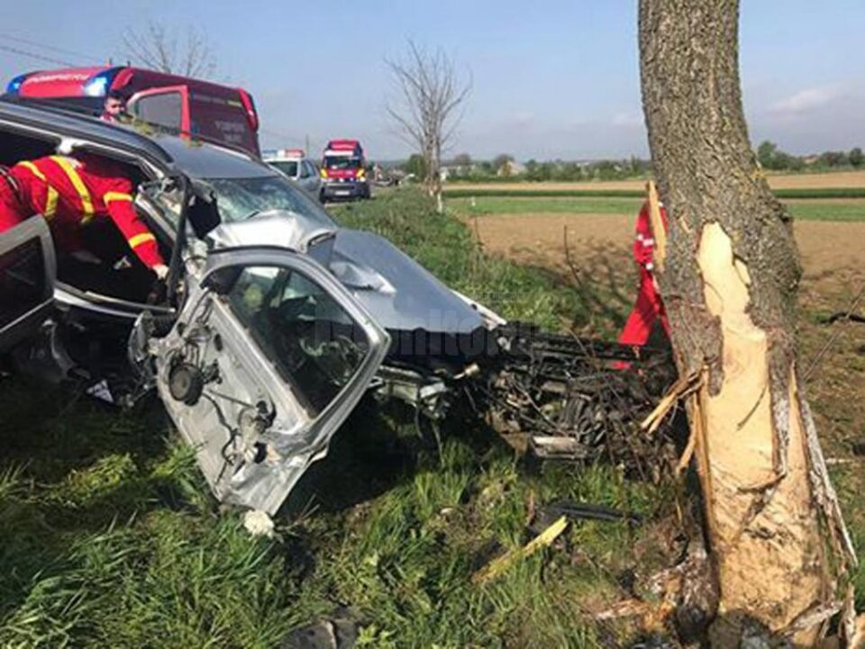 În urma impactului cu copacul de pe marginea drumului, bărbatul de 53 de ani aflat pe scaunul din dreapta a rămas încarcerat în mașină