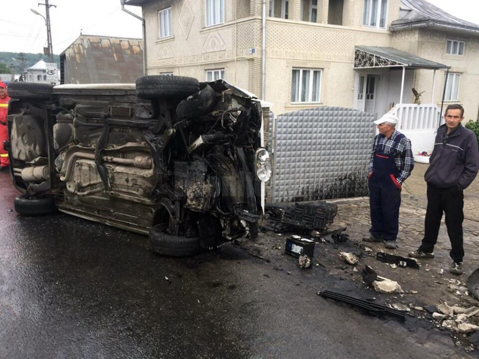 Autoturismul VW a lovit un stâlp și s-a răsturnat peste poarta unei case
