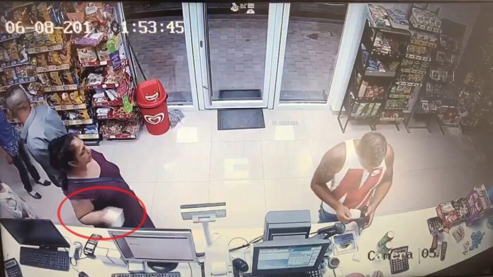 În imagine este surprins momentul în care sustrage pachetul și îl pune în geantă