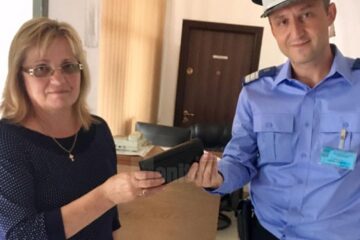 Plutonierul major Mihai Cusaci dându-i portmoneul femeii care l-a pierdut