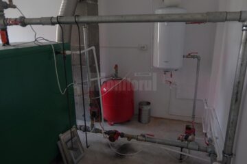 În camera centralei, cablurile atârnă peste echipamentele de încălzire