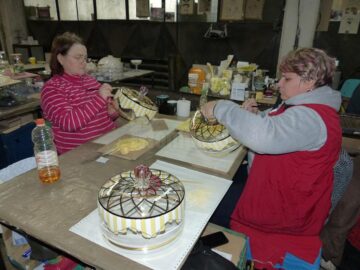 Cake-stand-uri pictate manual în secția de decorare a firmei