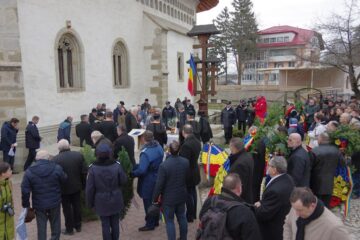 Coroane de flori depuse la troiță