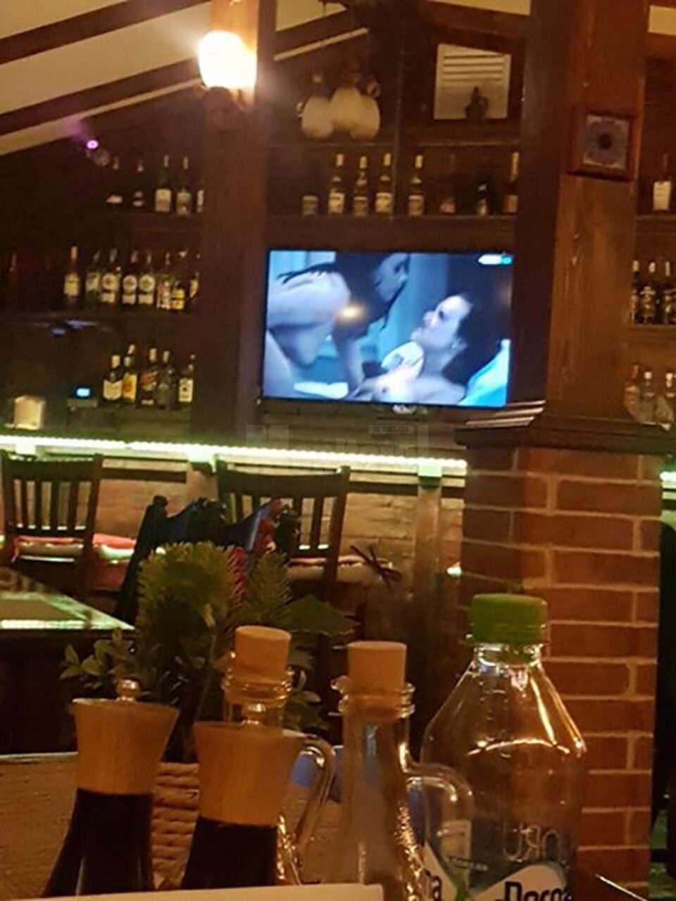 Pe ecranul televizorului situat deasupra barului au rulat scene porno, dintr-un film pentru adulți