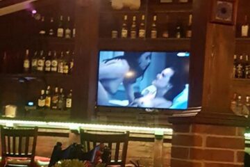 Pe ecranul televizorului situat deasupra barului au rulat scene porno, dintr-un film pentru adulți
