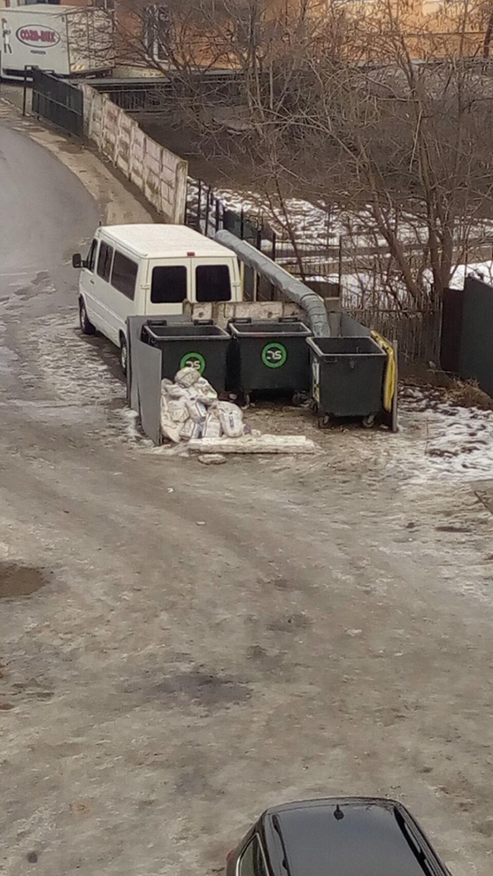 Deșeuri din construcții aruncate lângă coșul de gunoi