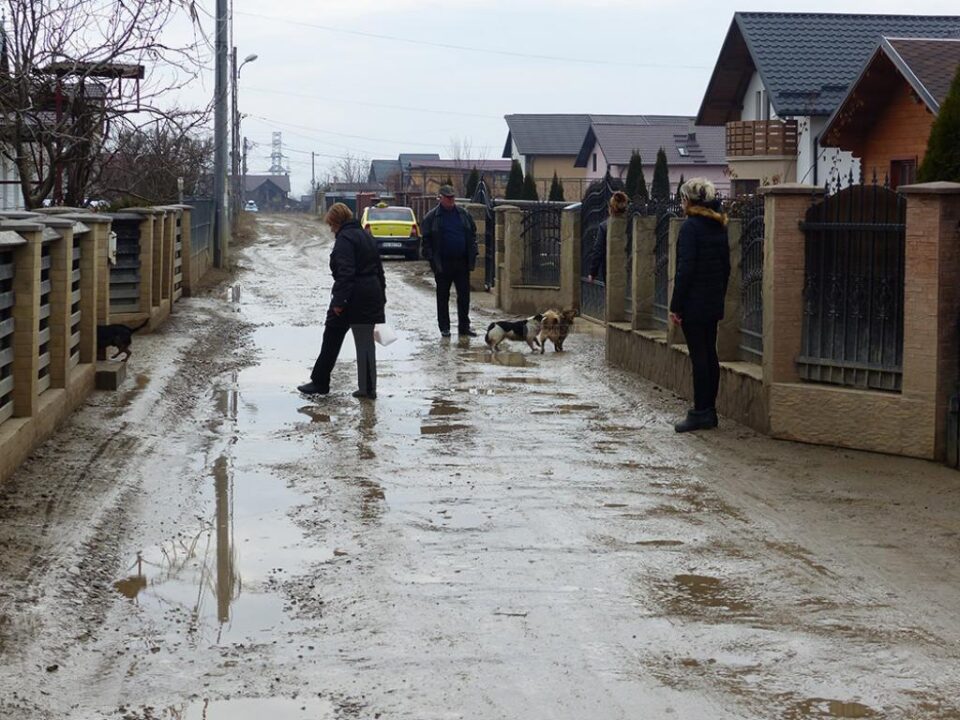 Locuitorii străzii circulă cu greu prin noroiul format pe drumul fără scurgeri pluviale Locuitorii străzii circulă cu greu prin noroiul format pe drumul fără scurgeri pluviale
