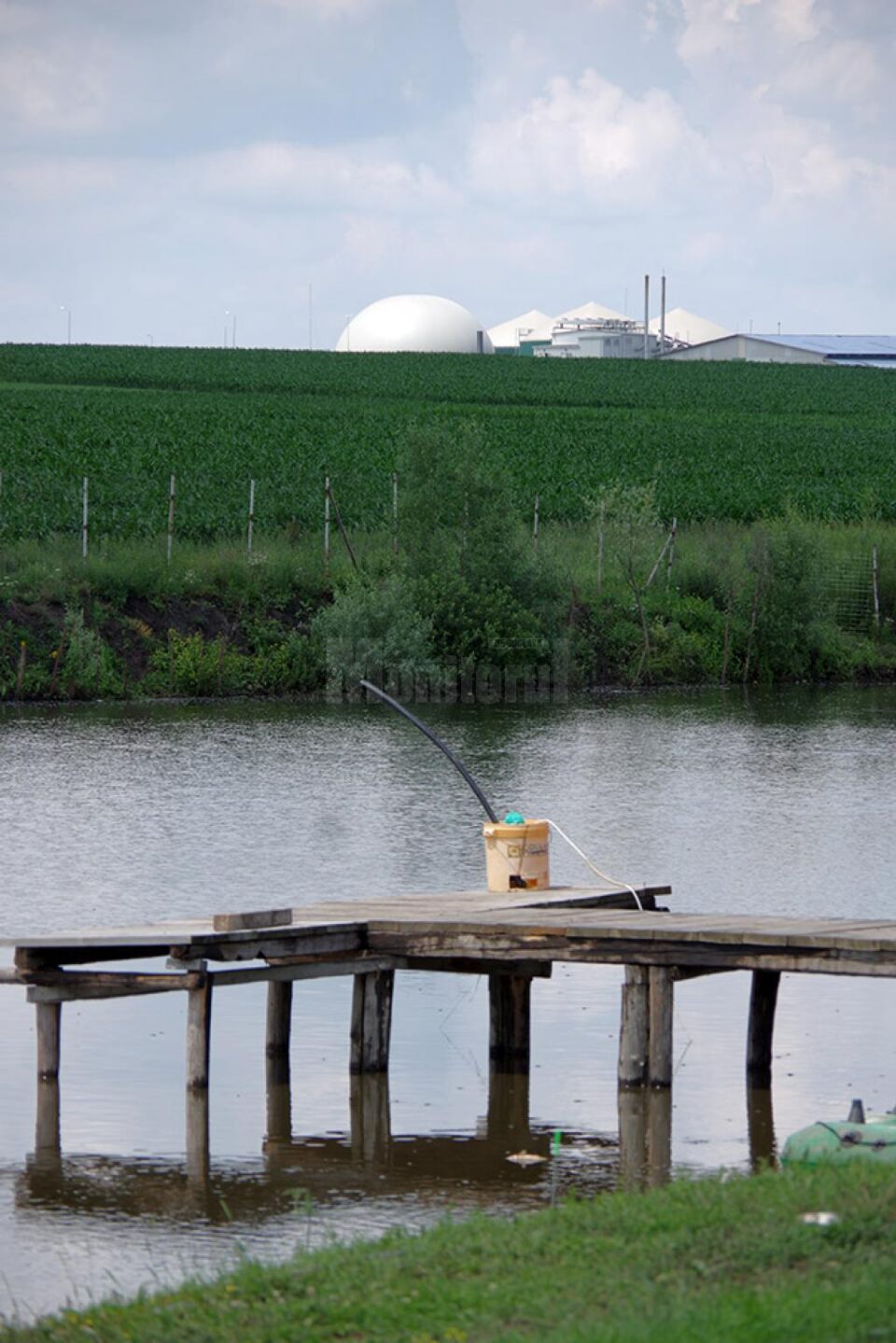 Iazul și stația de biogaz, în plan îndepărtat