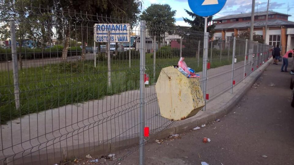 Coș de gunoi, arhiplin, prins artizanal cu sârmă de gardul împrejmuitor