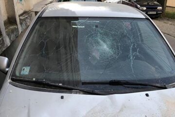 Mașina avariată de tencuiala căzută de pe bloc în bucăți mari