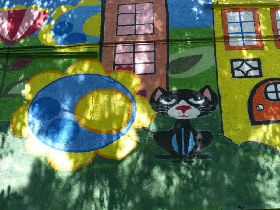 În centrul picturii figurează pisica neagră Elvira, mascota colegiului