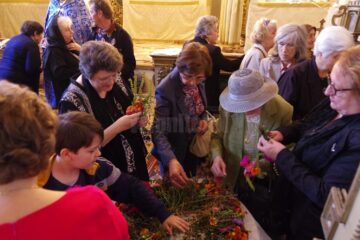 Credincioșii iau acasă buchetele de flori sfințite, care se pun la icoane