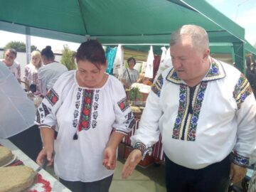 Primarul Gheorghe Fron invită oaspeții să guste turta cu julfă
