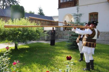 Pelerinii de la Putna, întâmpinați în poarta mănăstirii de starețul Melchisedec, cu icoana Sfântului Voievod Ștefan, spre închinare