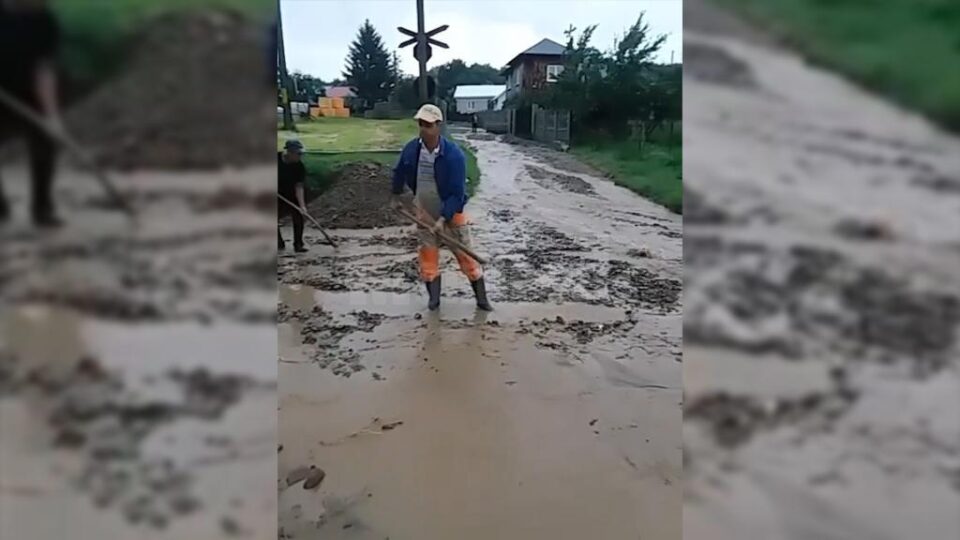 Tren cu călători, blocat de apă și aluviuni