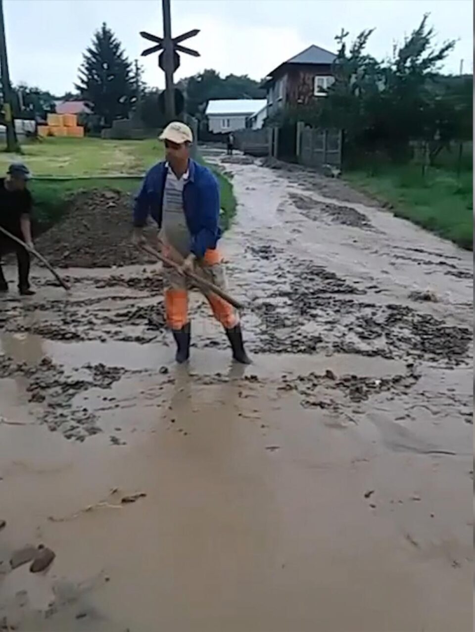 Tren cu călători, blocat de apă și aluviuni