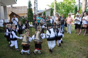 Oaspeții, întâmpinați la liceul din Moldovița de un grup de copii dansând tradițional