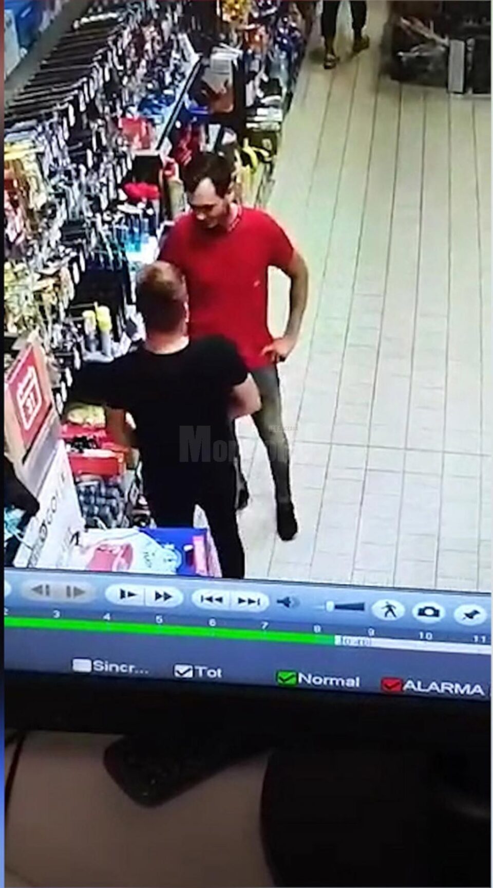 Tânărul aflat cu spatele ascunde un odorizant în pantaloni