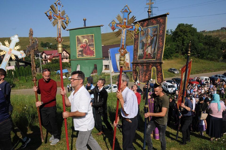 Procesiunea de urcare a colinei, cu prapuri, înainte de Sfânta Liturghie