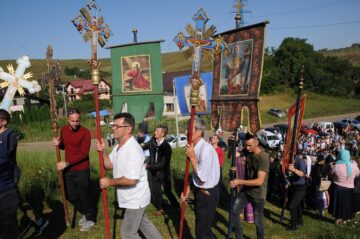 Procesiunea de urcare a colinei, cu prapuri, înainte de Sfânta Liturghie