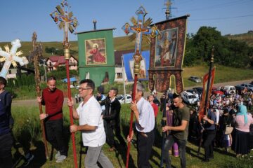 Procesiunea de urcare a colinei, cu prapuri, înainte de Sfânta Liturghie