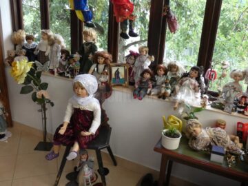 Zeci de păpuși de porțelan, cu chipuri expresive, te întâmpină chiar de la intrare în casa-muzeu de la Cajvana