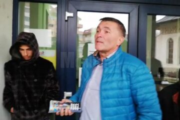 Autorul tâlhăriei, în stânga, cu gluga pe cap, prins de cei care au intervenit