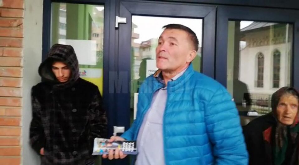 Autorul tâlhăriei, în stânga, cu gluga pe cap, prins de cei care au intervenit