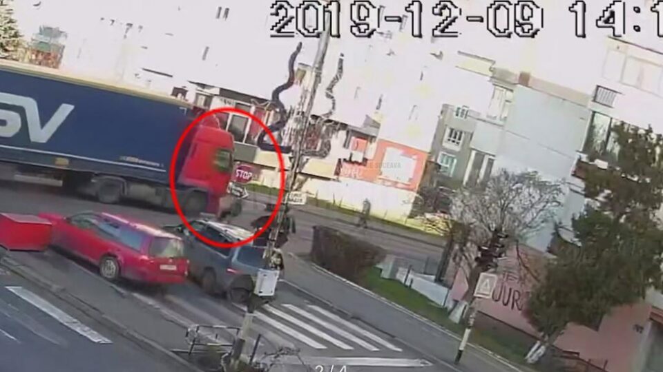 În imagine se vede momentul în care femeia, aflata în dreapta cabinei tirului, este trântită la pământ În imagine se vede momentul în care femeia, aflata în dreapta cabinei tirului, este trântită la pământ