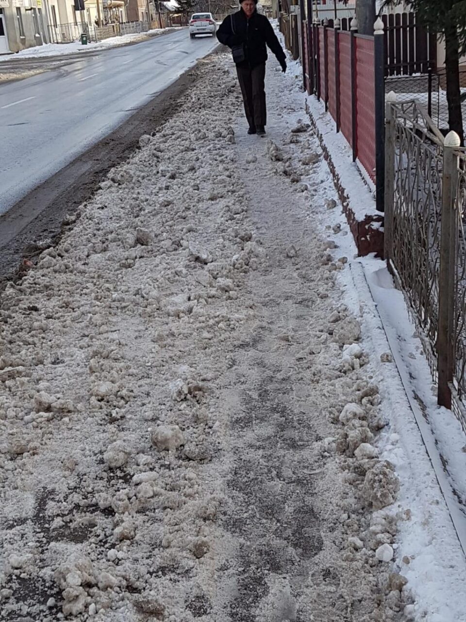 Trotuar acoperit de zăpada aruncată de pe carosabil, după ce a fost curățat de locuitorii de pe strada Biruinței