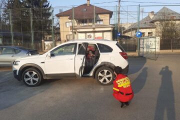 Alina, medic rezident în Iași, stă la o distanță de câțiva metri de mașina soțului ei, care are portiera deschisă, iar pe bancheta din spate se află fetița ei, în vârstă de 3 ani și jumătate
