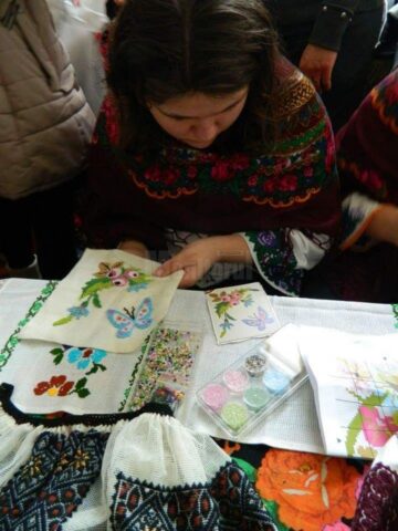 O tânără din Cajvana, elevă la Colegiul ”Mihai Eminescu” Suceava, coase cămăși, curele și chimire cu mărgele