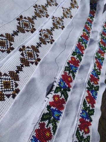 O tânără din Cajvana, Diana Seserman, coase cămăși, curele și chimire cu mărgele