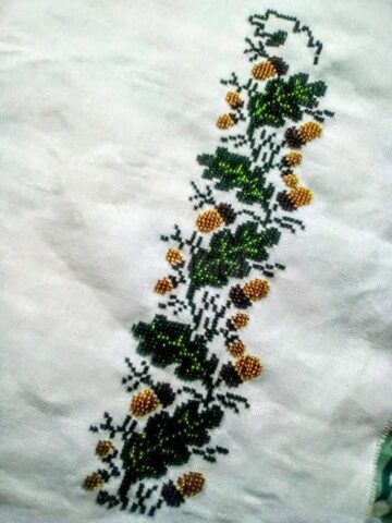 O tânără din Cajvana, Diana Seserman, coase cămăși, curele și chimire cu mărgele