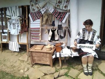 O tânără din Cajvana, Diana Seserman, coase cămăși, curele și chimire cu mărgele