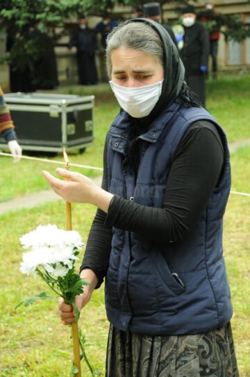 Flori și o lumânare aprinăa în semn de ultim omagiu