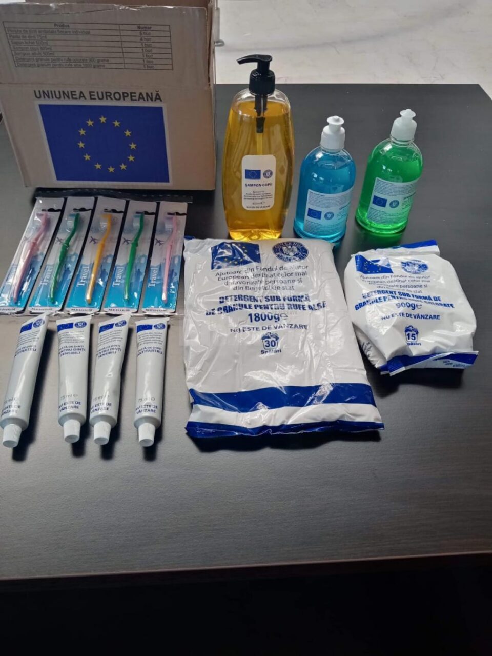 Un pachet de produse de igienă conține periuțe de dinți, pastă de dinți, săpun lichid, șampon copii, șampon adulți, detergent rufe