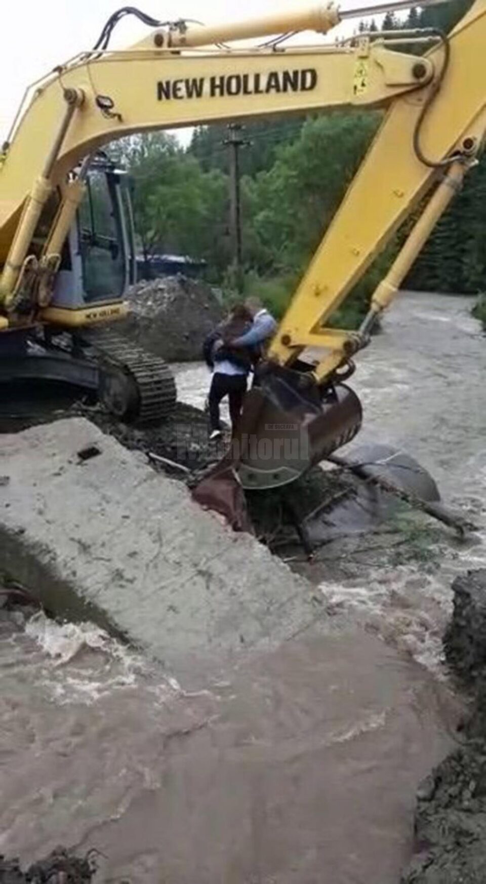 Adolescentă trecută în cupa excavatorului peste râul Brodina pentru a putea fi preluată de ambulanță Adolescentă trecută în cupa excavatorului peste râul Brodina pentru a putea fi preluată de ambulanță