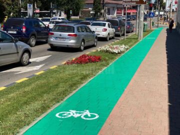 Pistele de bicicletă marcate cu vopsea verde se diferențiază de trotuarul alocat pietonilor și prin suprafața poroasă