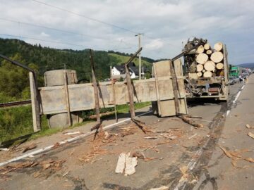 Mai mulți bușteni care se aflau în remorca camionului au zburat pe carosabil