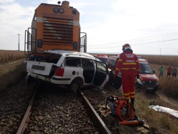 Mașina a fost lovită în plin de un tren la o trecere la nivel aflată în câmp