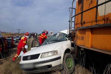 Mașina a fost lovită în plin de un tren la o trecere la nivel aflată în câmp