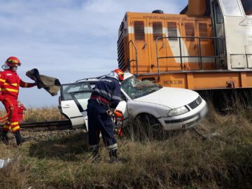 Mașina a fost lovită în plin de un tren la o trecere la nivel aflată în câmp