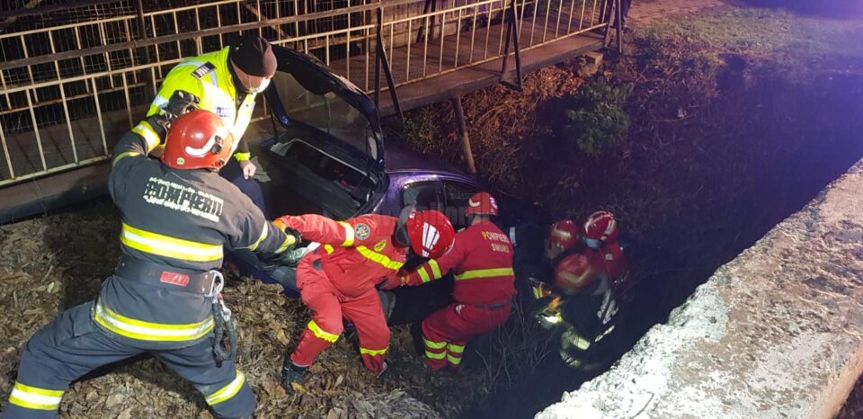 Mașină răsturnată în albia unui pârâu. Șoferul, găsit încarcerat, prins sub bord