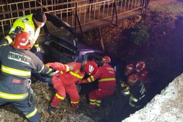 Mașină răsturnată în albia unui pârâu. Șoferul, găsit încarcerat, prins sub bord