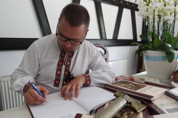 Autorul Petru Torac oferind autografe pe volumul de fotografie publicat