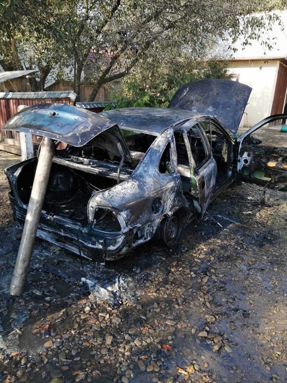 Un autoturism a ars violent în curtea unei case