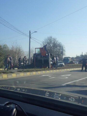 Vehicul greu care transporta asfalt, răsturnat, ieri, pe strada Traian Vuia