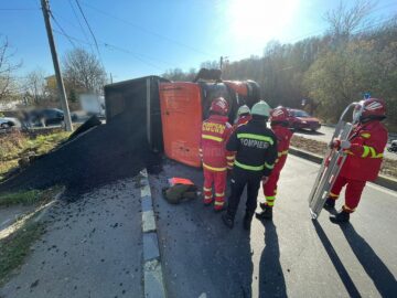 Vehicul greu care transporta asfalt, răsturnat, ieri, pe strada Traian Vuia
